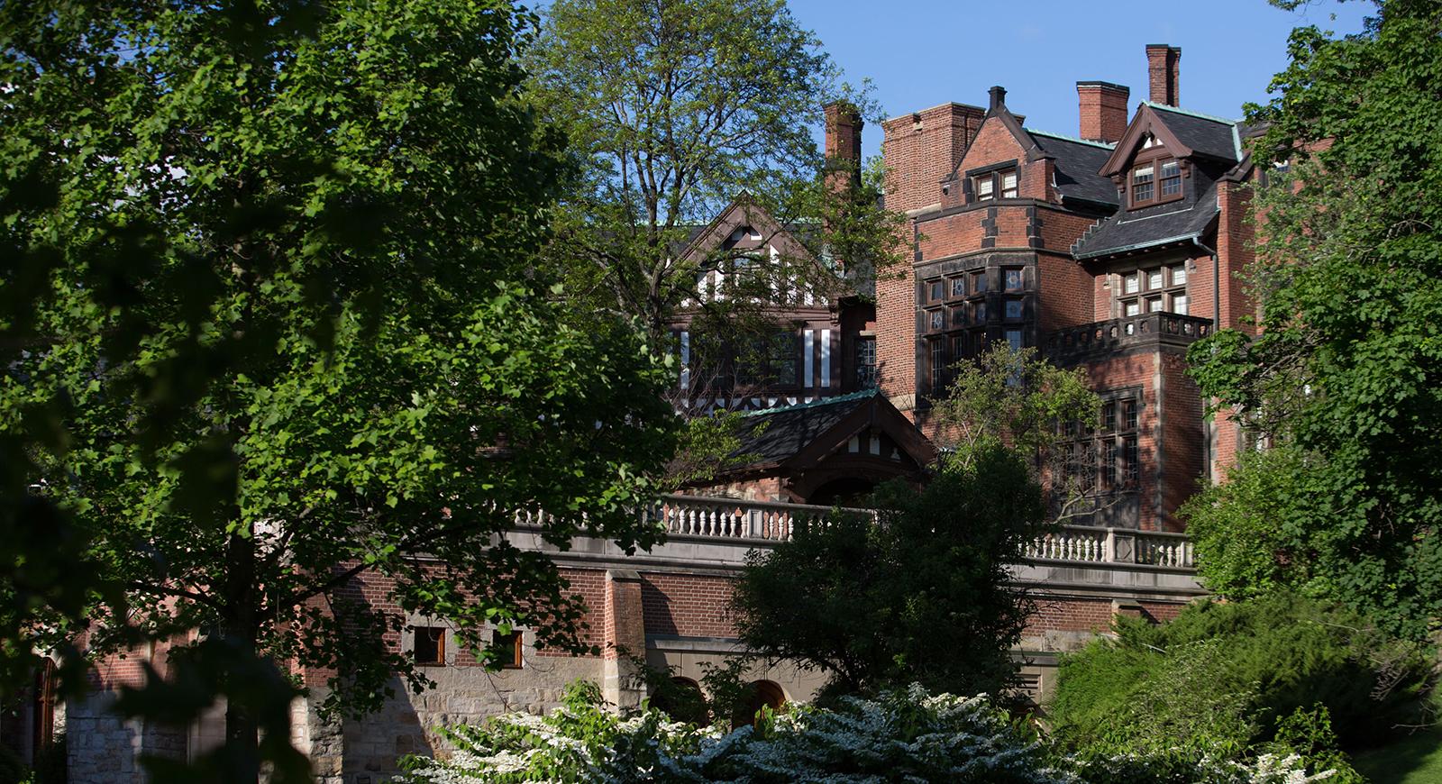 Photo of an historic red brick building sitting on Chatham University's Shadyside Campus. 