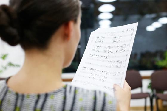 Photo of a woman with dark hair reading sheet music